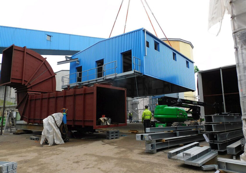 Blaues Blechgebäude, an einem Kran.